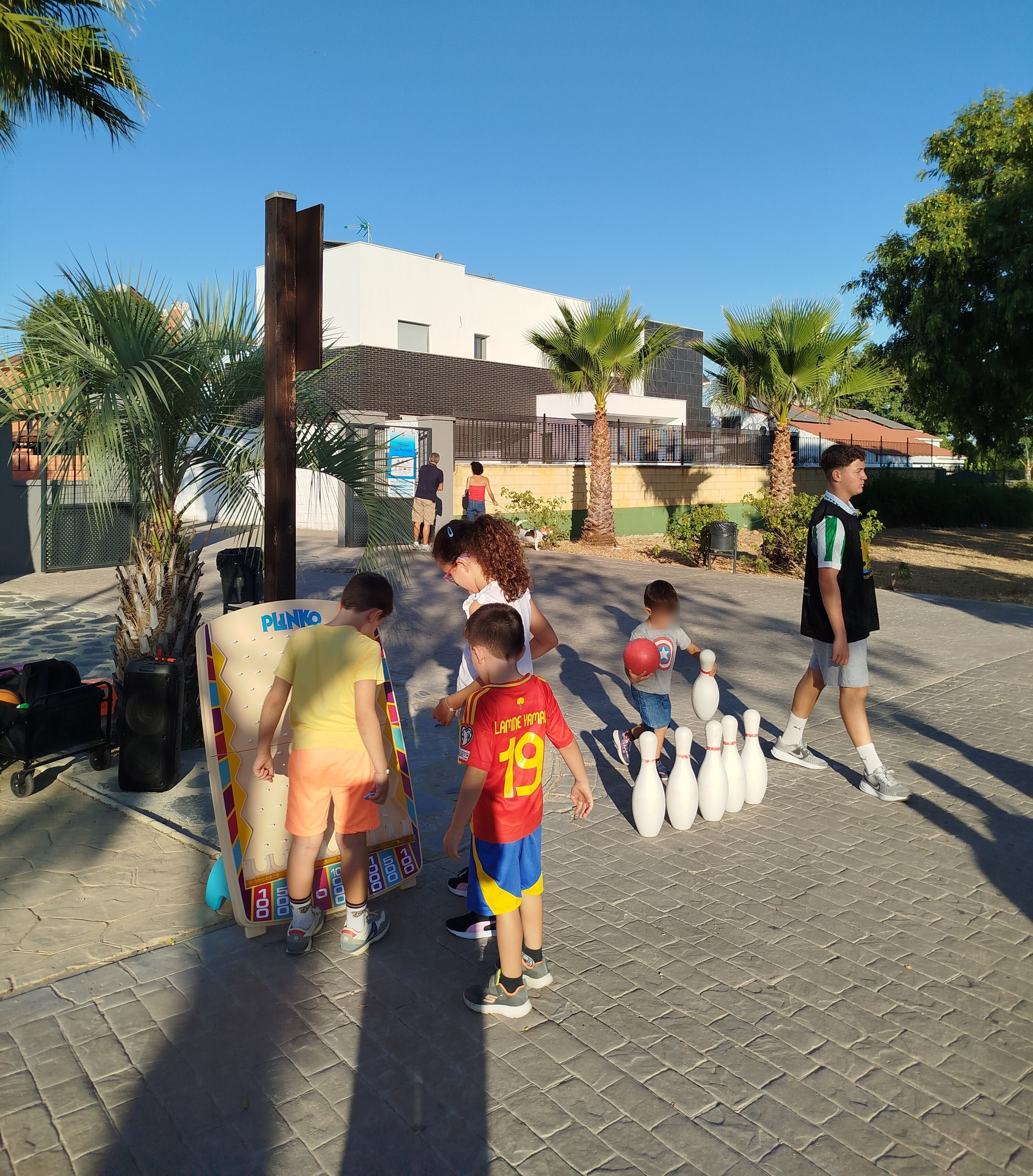 En esta imagen se puede observar a varios niños y niñas celebrando un cumpleaños en un parque infantil al aire libre, realizando diferentes actividades a la vez.