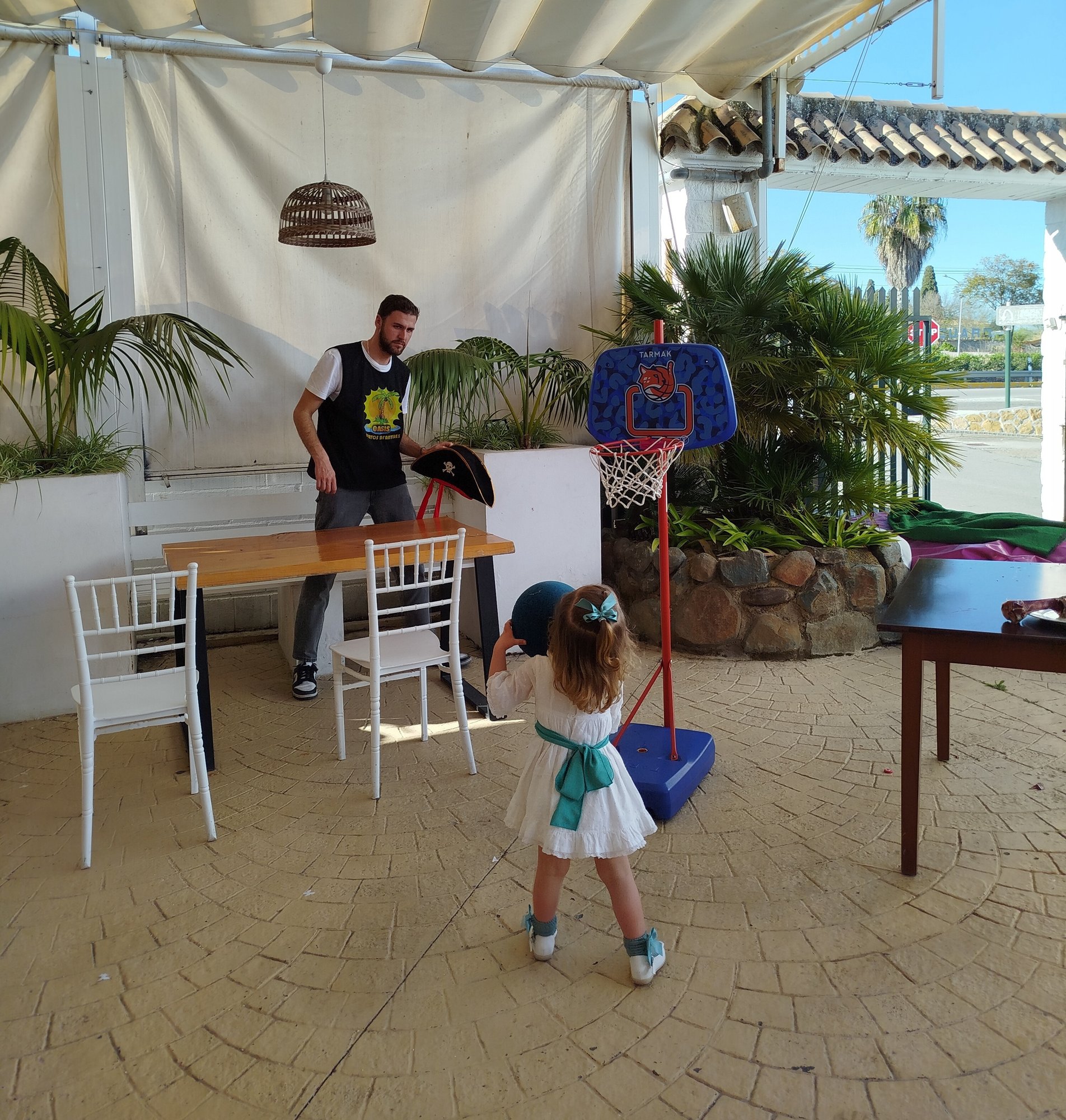 En esta imagen se puede ver a una niña probando una canasta de baloncesto en una boda.