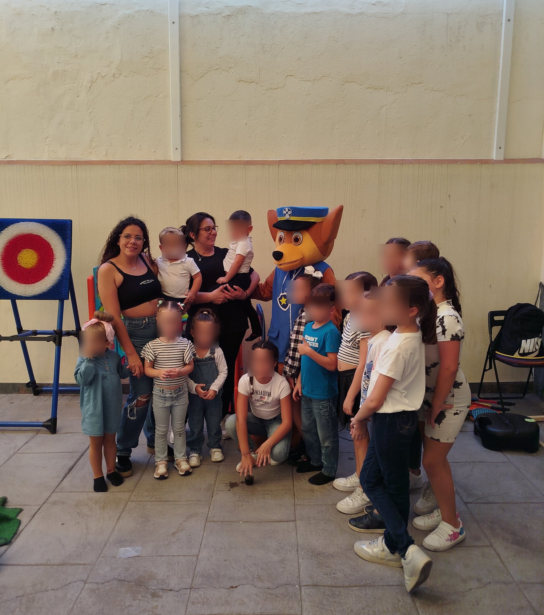 En la imagen se puede observar como un animador disfrazado de Chaise (Personaje de la Patrulla Canina), se hace una foto con los niños/as en un cumpleaños infantil.