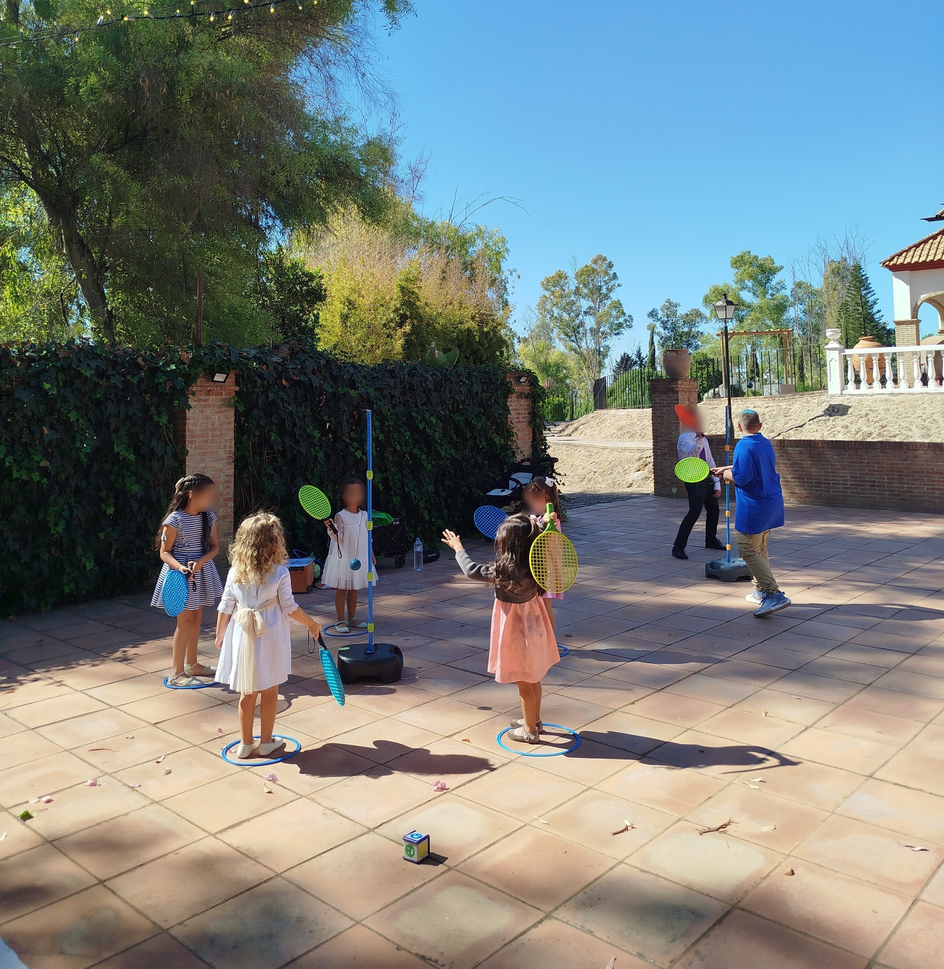 En esta imagen se puede observar a varios niños y niñas realizando una actividad infantil muy divertida con raquetas.